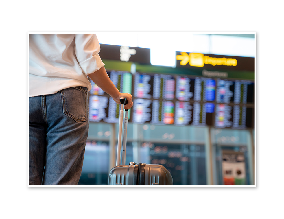 Woman in an airport holding a suitcase