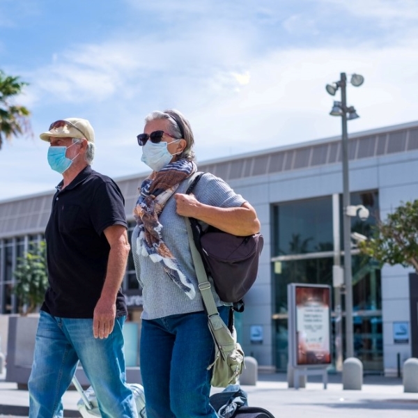 older couple leaving airport wearing masks 