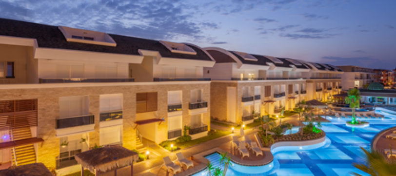 A photo of the exterior of a hotel building and pool